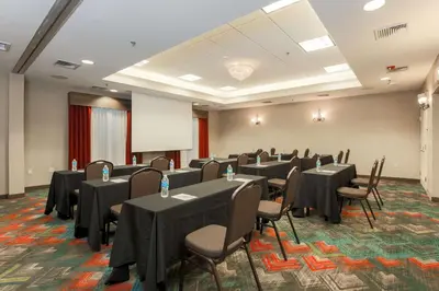 a conference room with tables and chairs and a screen at Hilton Garden Inn Nanuet in Nanuet