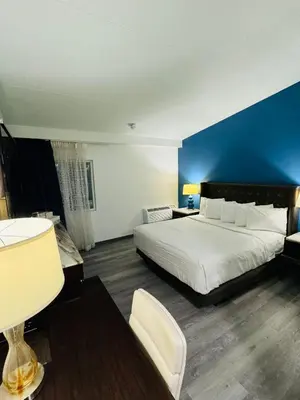 a bedroom with a large bed and a blue wall at Inn at York in York