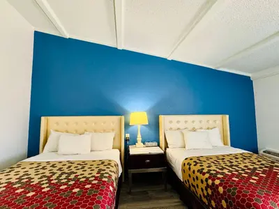 two beds in a room with a blue wall at Inn at York in York