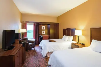 a hotel room with two beds and a flat screen tv at Hampton Inn Selinsgrove/Shamokin Dam in Shamokin Dam