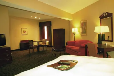a hotel room with a bed and a living room at Hampton Inn Selinsgrove/Shamokin Dam in Shamokin Dam