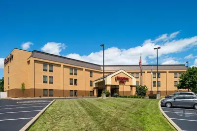 a building with a car parked in a parking lot at Hampton Inn Selinsgrove/Shamokin Dam in Shamokin Dam