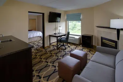 a hotel room with a couch and a fireplace at Hampton Inn Harrisburg/Grantville/Hershey in Grantville