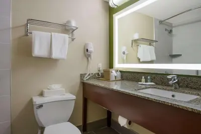 a bathroom with a toilet and a sink with a phone at Quality Inn Near Princeton in Lawrence
