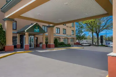 a hotel with a parking lot in front of a building at Quality Inn Near Princeton in Lawrence