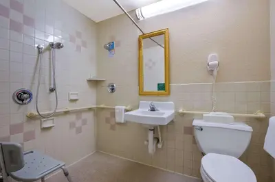 a bathroom with a toilet and a sink and a mirror at Quality Inn Near Princeton in Lawrence