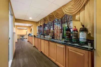 a long corridor with a bar with bottles of alcohol at Quality Inn Near Princeton in Lawrence