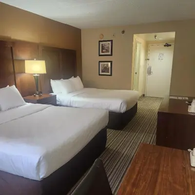 a hotel room with two beds and a table at Best Western Chocolate Inn at the Park in Hummelstown