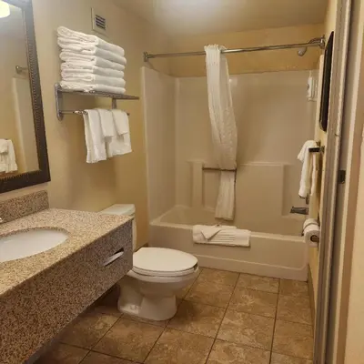 a bathroom with a toilet and a sink and a tub at Best Western Chocolate Inn at the Park in Hummelstown
