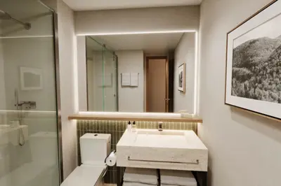 a bathroom with a sink and a toilet and a mirror at DoubleTree by Hilton Wilkes-Barre in Wilkes-Barre