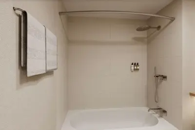 a white bathroom with a shower and a toilet at DoubleTree by Hilton Wilkes-Barre in Wilkes-Barre