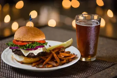 a plate with a hamburger and french fries and a glass of beer at DoubleTree by Hilton Wilkes-Barre in Wilkes-Barre