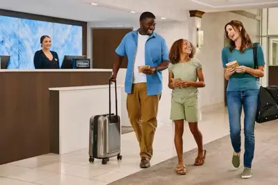 a group of people walking through an airport with their luggage at DoubleTree by Hilton Wilkes-Barre in Wilkes-Barre