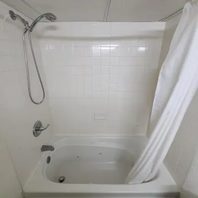 a bathroom with a bath tub with a shower at Town Inn in Bordentown