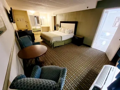 a hotel room with a bed and chairs and a table at Town Inn in Bordentown