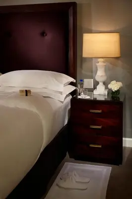a bedroom with a bed with a nightstand with a lamp at Trump International New York in New York