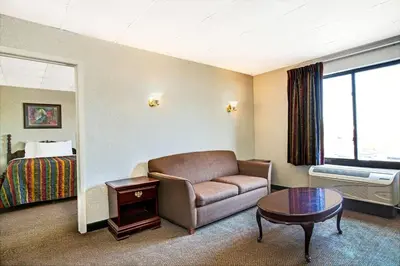 a hotel room with a couch and a table and a bed at Days Inn by Wyndham Parsippany in Parsippany