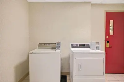two washing machines and a red door in a room at Days Inn by Wyndham Parsippany in Parsippany
