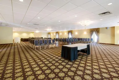 a room with chairs and tables and a room with tables and chairs at Exton Hotel and Conference Center in Exton