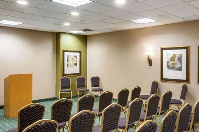 an empty room with chairs and pictures on the wall at Exton Hotel and Conference Center in Exton