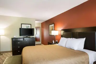 a hotel room with a bed and a flat screen tv at Exton Hotel and Conference Center in Exton