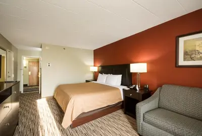 a hotel room with a bed and a chair at Exton Hotel and Conference Center in Exton