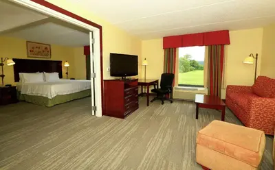 a hotel room with a bed and a television at Hampton Inn and Suites of Lamar in Mill Hall