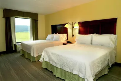 a hotel room with two beds and a window at Hampton Inn and Suites of Lamar in Mill Hall