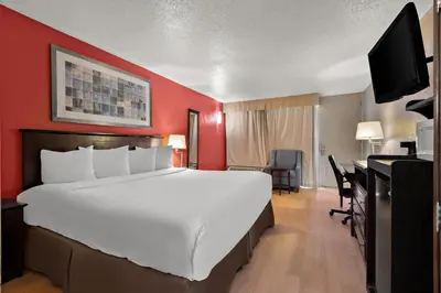 a large white bed in a room with a red wall at Quality Inn Wayne - Fairfield Area in Wayne