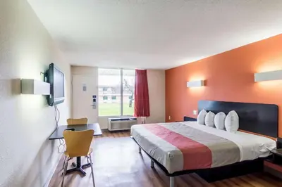 a hotel room with a bed and a large window at Motel 6 New Brunswick in New Brunswick