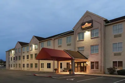 a hotel with a red awning in a parking lot at Lancaster Suites in Lancaster