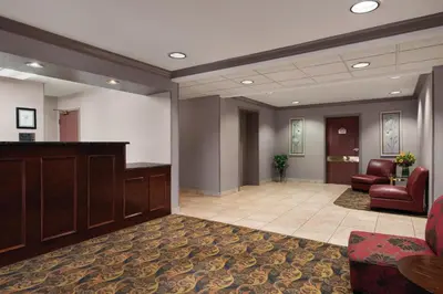 a lobby with a waiting area with chairs and a desk at Lancaster Suites in Lancaster
