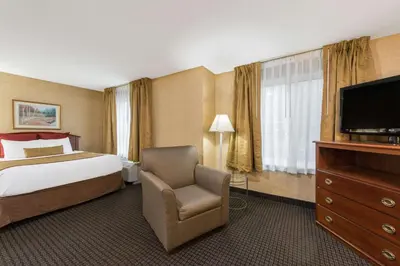 a hotel room with a bed and a television at Lancaster Suites in Lancaster