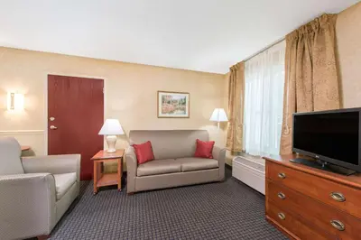 a hotel room with a couch and a flat screen tv at Lancaster Suites in Lancaster