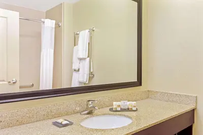 a bathroom with a sink and a large mirror at La Quinta by Wyndham Lancaster in Lancaster