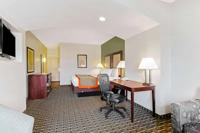 a hotel room with a desk and a bed at La Quinta by Wyndham Lancaster in Lancaster