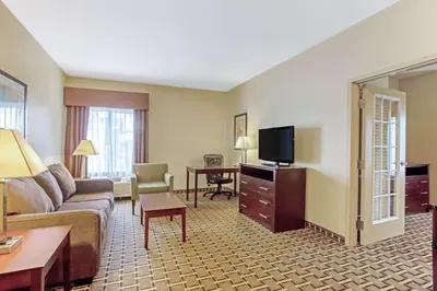 a hotel room with a couch and a television at La Quinta by Wyndham Lancaster in Lancaster