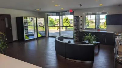 a lobby with a waiting area with chairs and tables at Motel 6 Lancaster in Lancaster