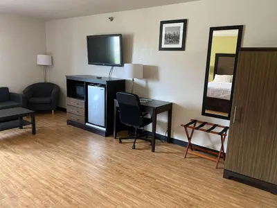 a hotel room with a bed and a desk with a television at Motel 6 Lancaster in Lancaster