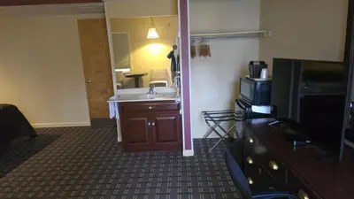a bathroom with a sink and a tv in a room at Classic Inn Lancaster in Lancaster