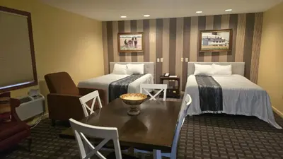 a hotel room with two beds and a table at Classic Inn Lancaster in Lancaster