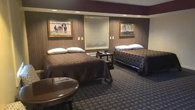 a hotel room with two beds and a table at Classic Inn Lancaster in Lancaster