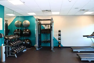 a fitness room with a gym with weights at avid hotels - Lancaster by IHG in Lancaster