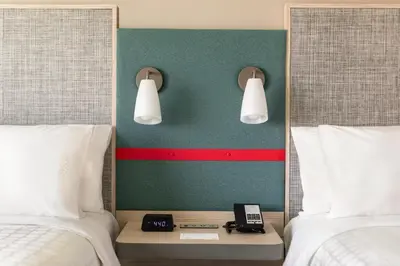 a hotel room with two beds and a phone on a table at avid hotels - Lancaster by IHG in Lancaster