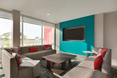 a living room with a couch and a tv on a wall at avid hotels - Lancaster by IHG in Lancaster