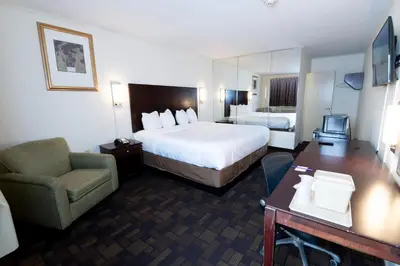 a hotel room with a bed and a chair and a desk at Knights Inn South Amboy in South Amboy