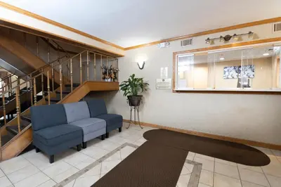 a living room with a blue couch and stairs at Knights Inn South Amboy in South Amboy