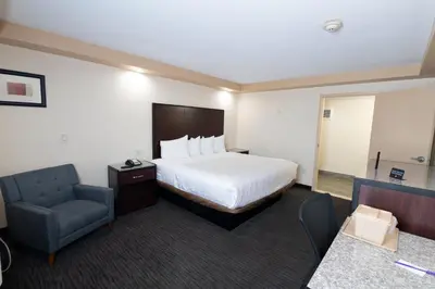 a hotel room with a bed and a chair at Knights Inn South Amboy in South Amboy