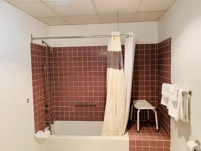 a bathroom with a tub and a toilet and a stool at Olde Amish Inn in Ronks
