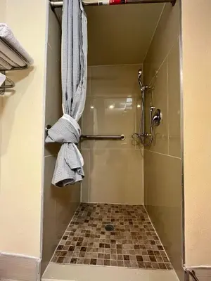 a bathroom with a shower with towels on a wall at Circle Motor Lodge in South Amboy